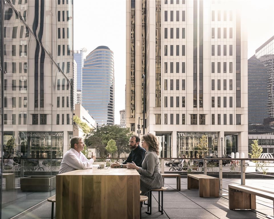 people eating outside on a table in the city