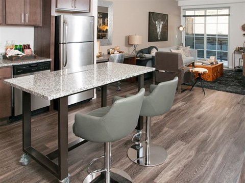 A kitchen with a table and chairs in the foreground.