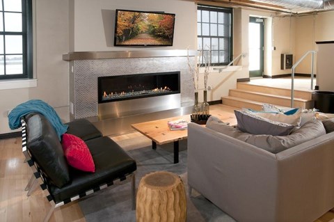 A living room with a fireplace and a painting above it.