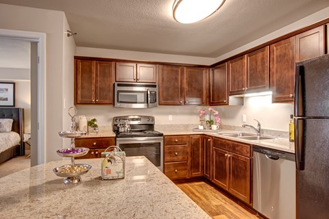 A kitchen with wooden cabinets and a granite countertop.