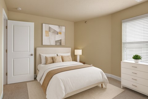 A bedroom with a bed, nightstand, and a painting on the wall.