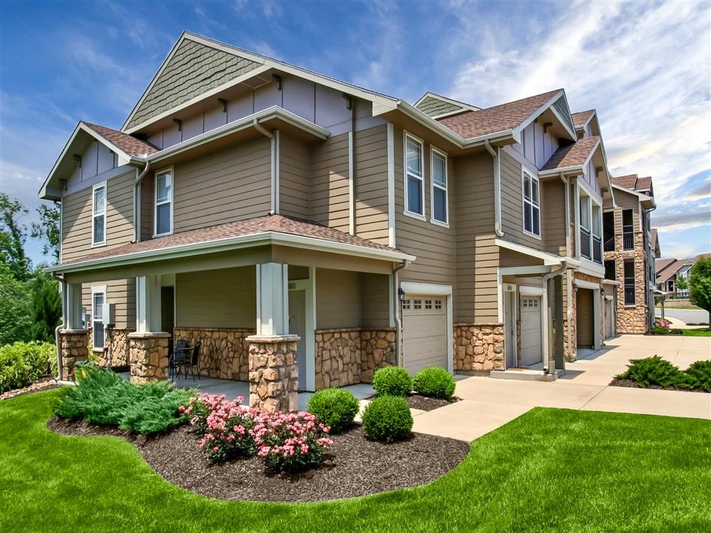 Stunning Exterior View of Riverstone Apartment Building in Daylight with Attached Garages and Driveways