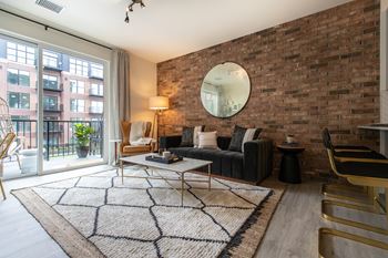 a living room with a brick wall and a sliding glass door