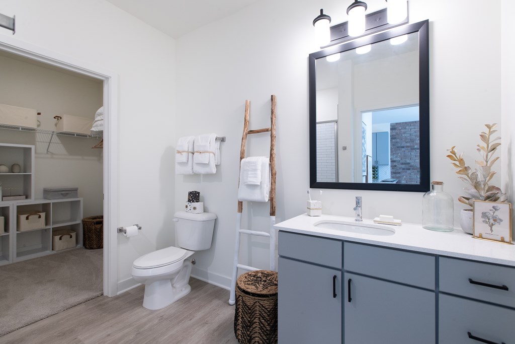 a bathroom with gray cabinets and white walls