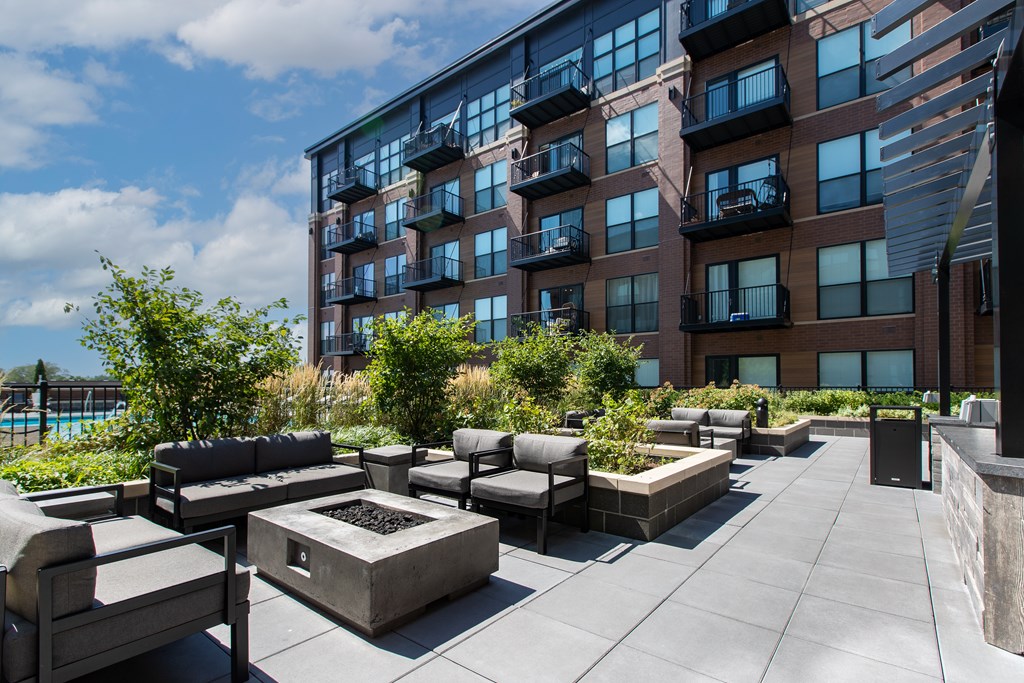 an outdoor patio with a firepit and seating
