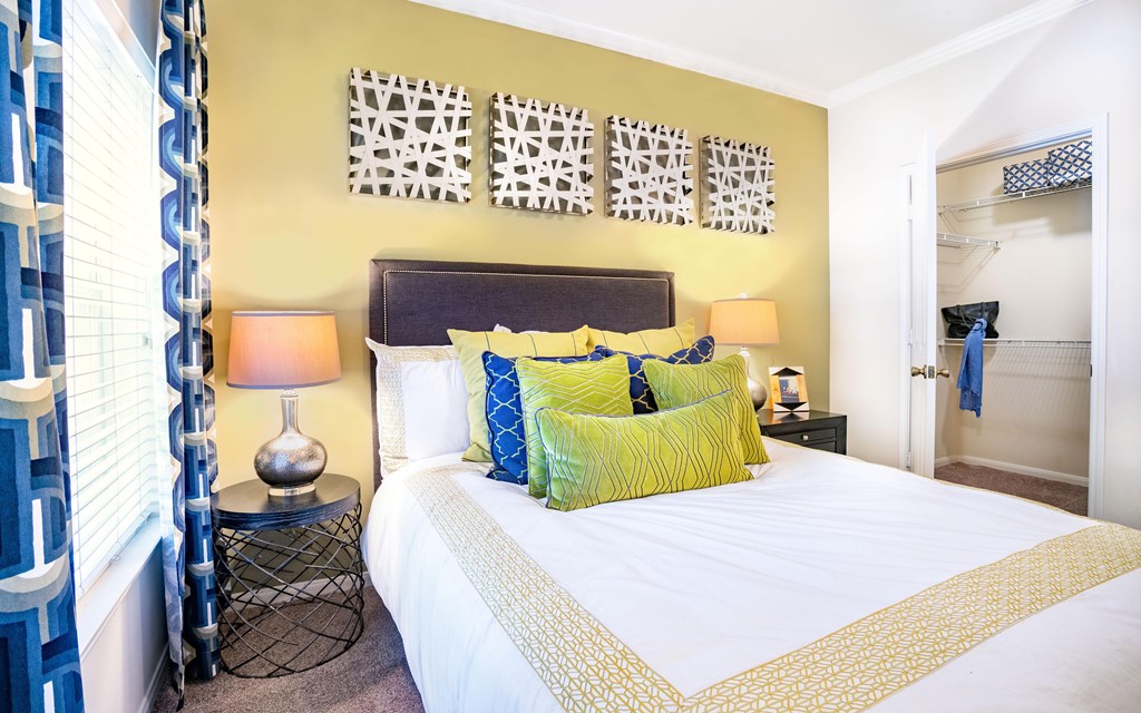 a bedroom with yellow walls and a white bed