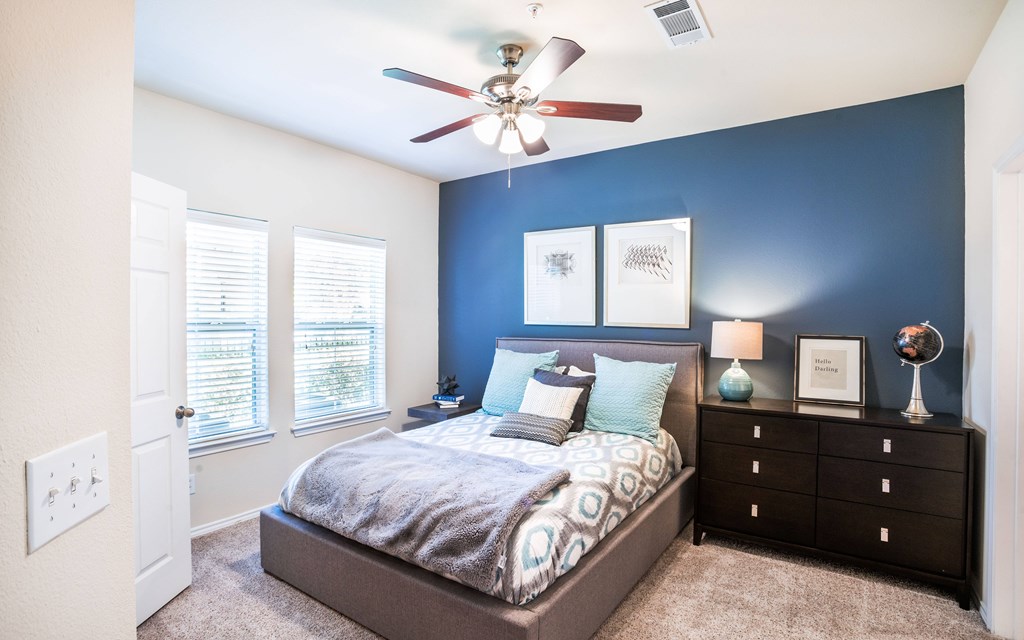 a bedroom with a large bed and a ceiling fan