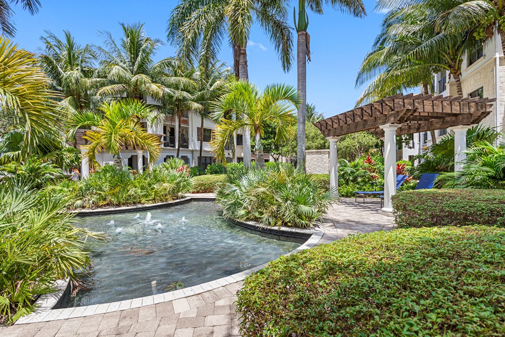 a swimming pool with palm trees and a house in the background