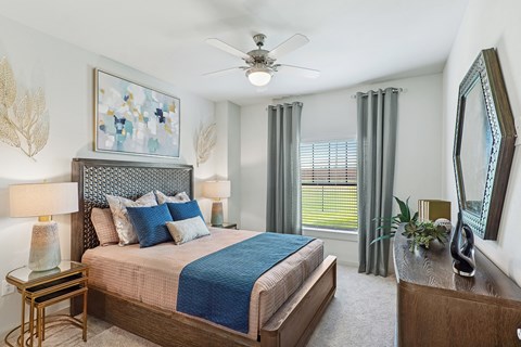 A bedroom with a large bed and a ceiling fan.