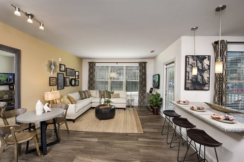 A living room with a white couch, a coffee table, and a dining table with chairs.