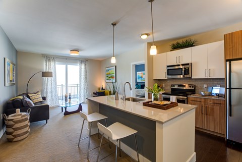 A kitchen with a white countertop and a dining table with chairs.
