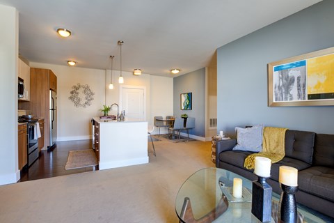 A living room with a couch, a coffee table, and a painting on the wall.