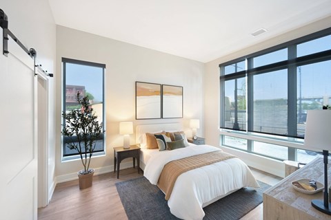 A bedroom with a large bed and a view of the city.