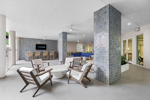 A living room with a white couch and a blue chair.