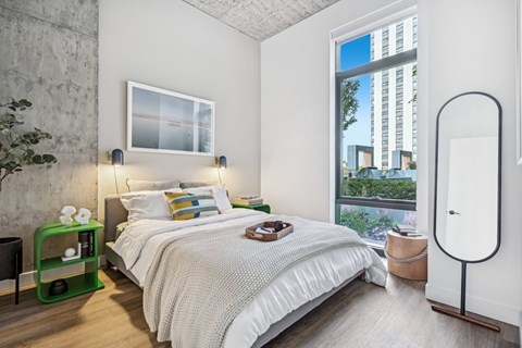 a bedroom with a bed and a large window