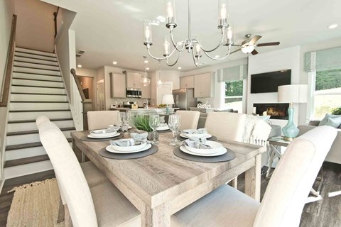 A dining room with a wooden table set for two.