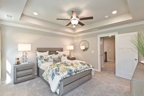 A bedroom with a large bed and a ceiling fan.
