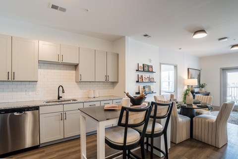 A modern kitchen with a dining table and chairs.