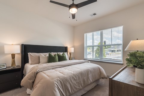 A bedroom with a large bed and a ceiling fan.