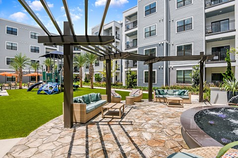 A patio with a table and chairs and a pool.