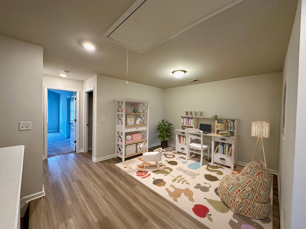 a living room with a play area and a blue door