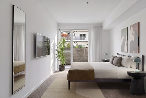 A bedroom with a large bed and a large mirror on the wall.