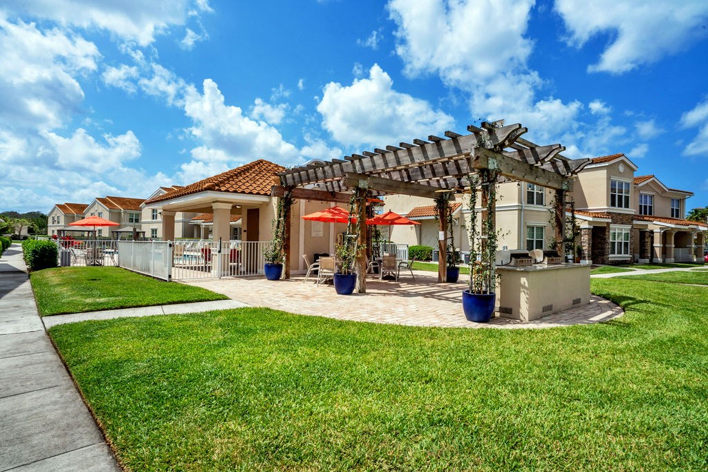 a patio with umbrellas in front of a house