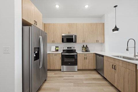 A modern kitchen with wooden cabinets and stainless steel appliances.