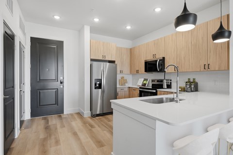 A modern kitchen with a white countertop and a stainless steel refrigerator.