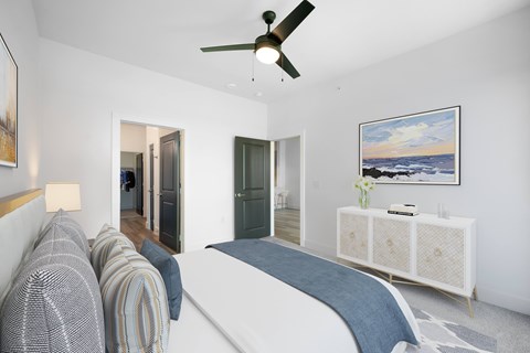 A bedroom with a bed, a dresser, and a painting on the wall.
