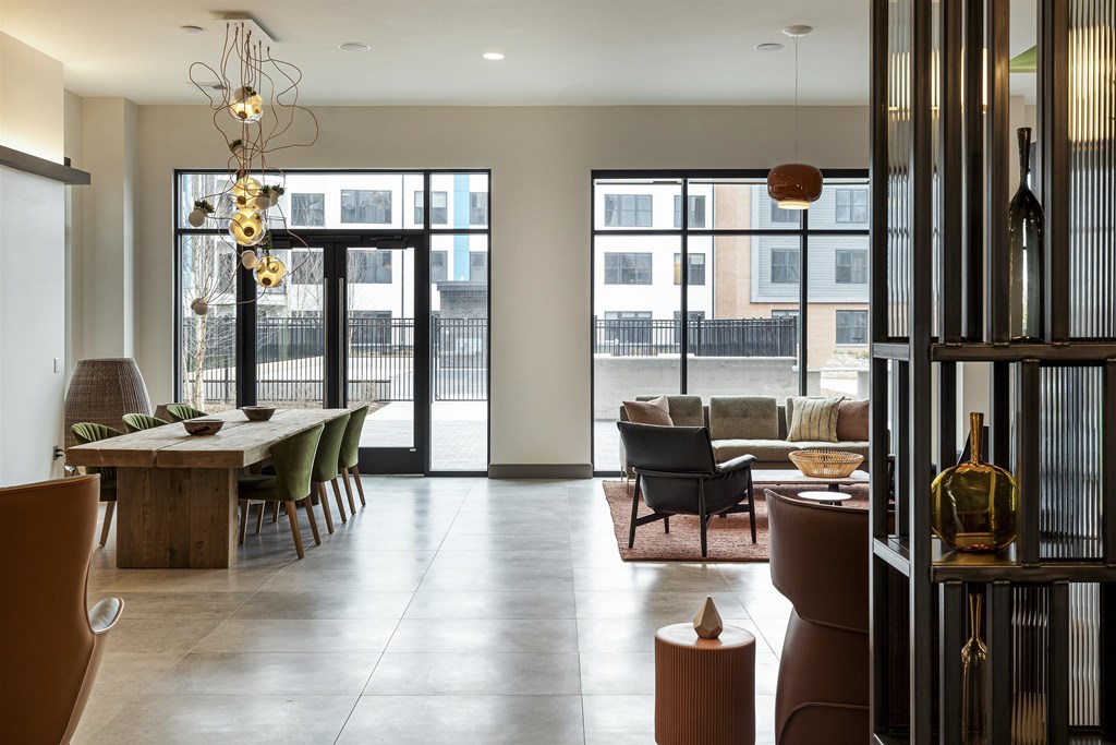 a living room and dining room with large windows and a table and chairs