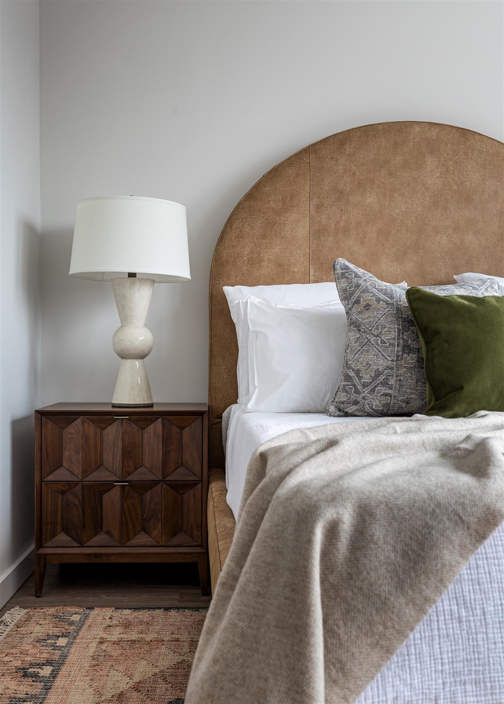 a bedroom with a bed and a nightstand with a lamp