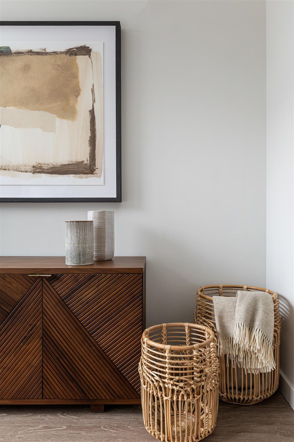 a living room with baskets and a painting on the wall