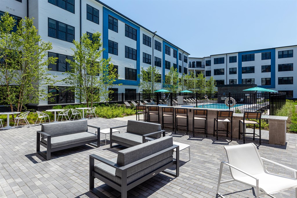 a patio with furniture and a pool in front of a building