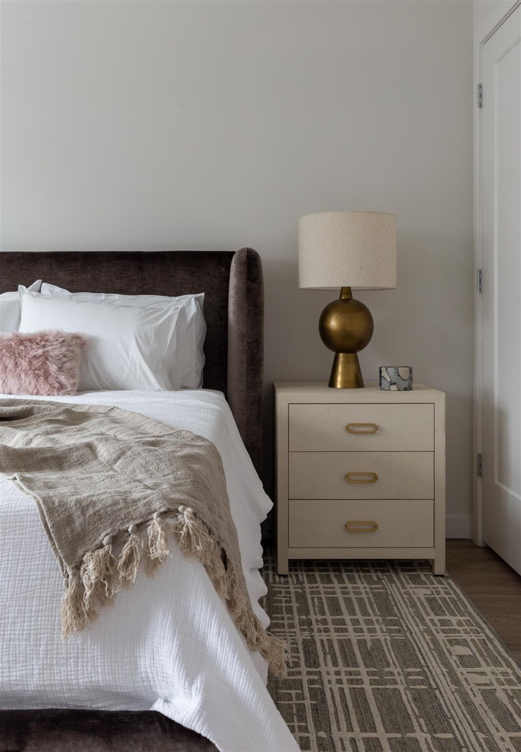 a bedroom with a bed and a nightstand with a lamp