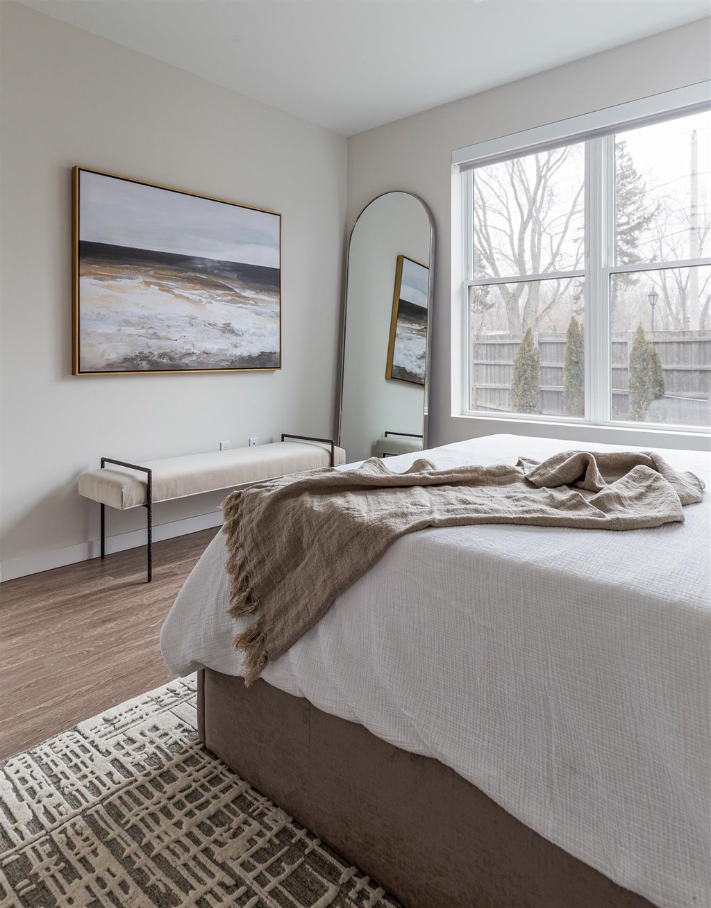 a bedroom with a bed and two windows