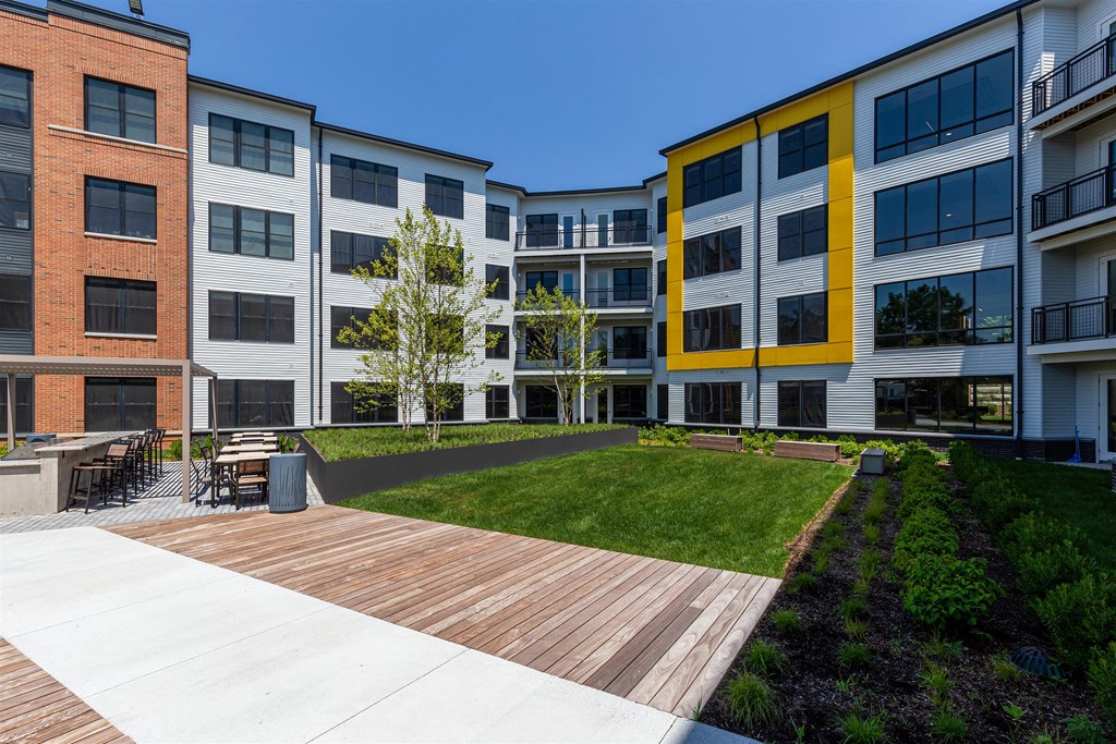 modern apartment buildings with a lawn and wooden walkway