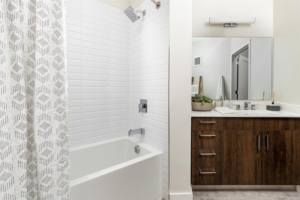 a bathroom with a tub and a sink and a mirror