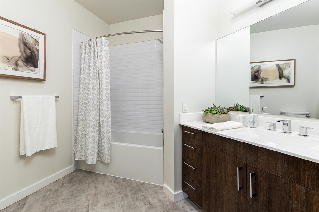 a bathroom with a shower and a sink and a mirror