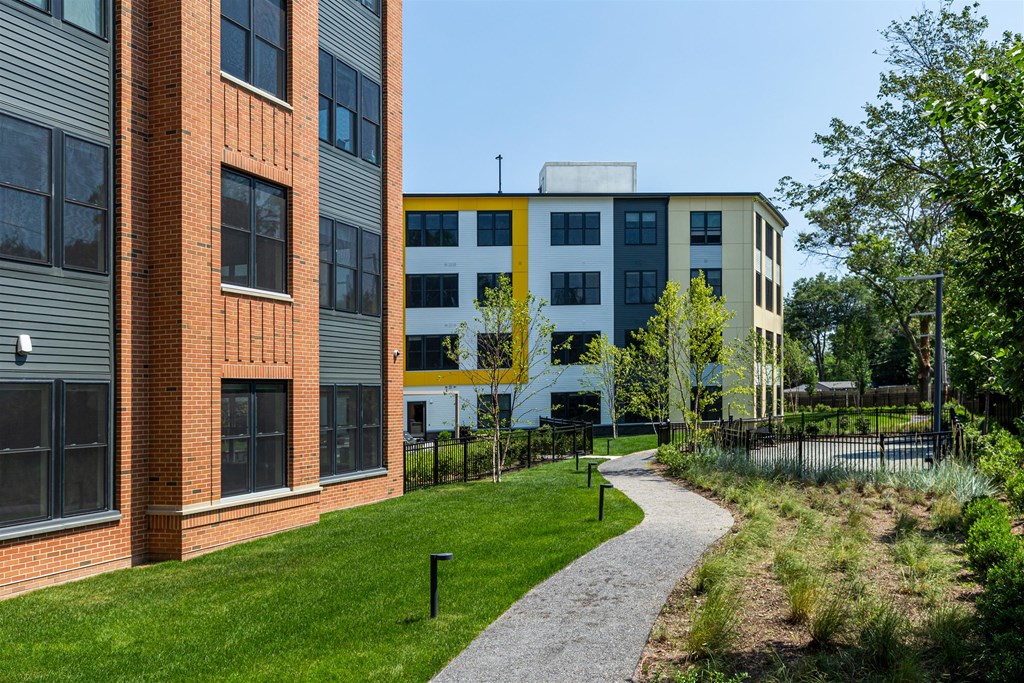 a path leading to a building with grass and trees