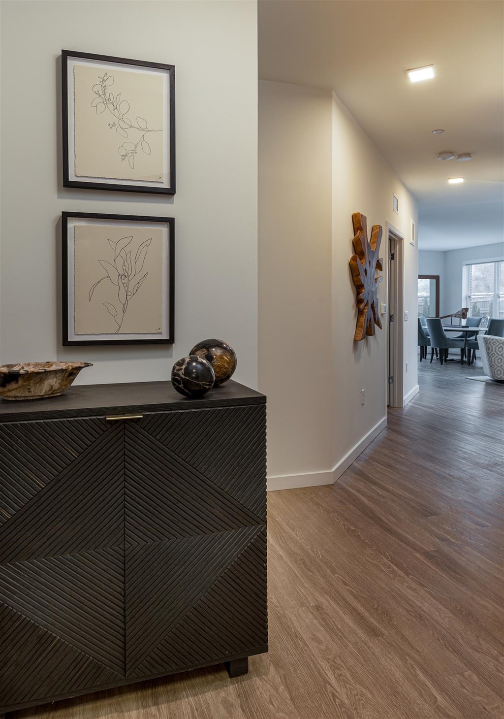 a hallway with a dresser and pictures on the wall