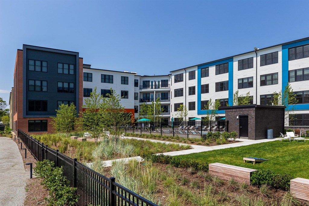 an exterior view of a group of buildings with grass and trees