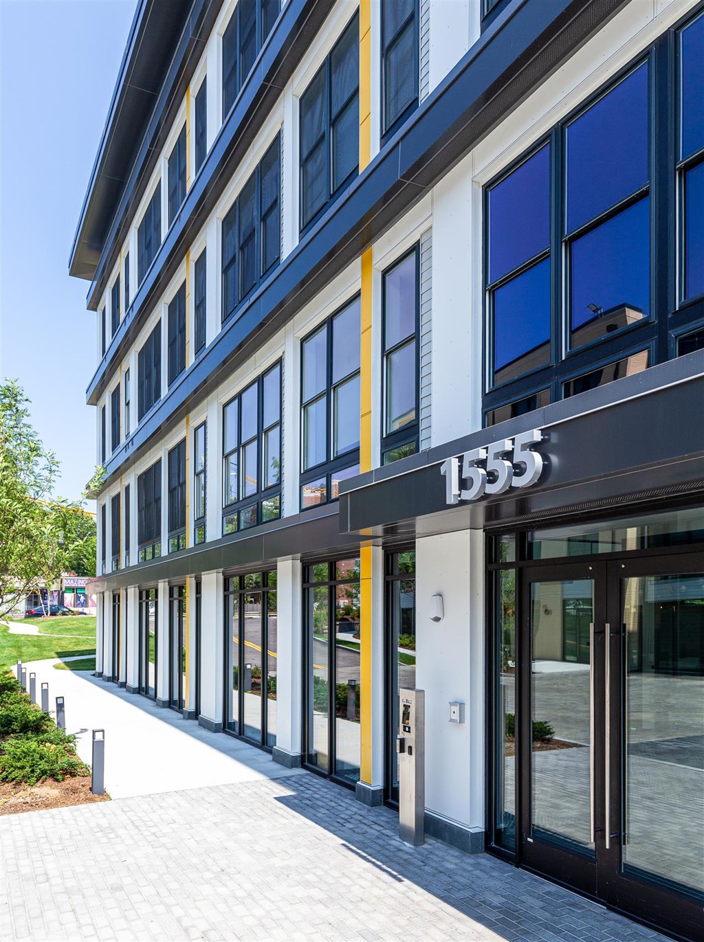 front of a building with glass doors and a sidewalk
