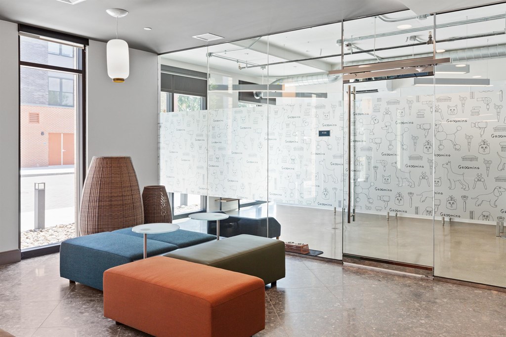 a room with couches and a glass wall with drawings on it