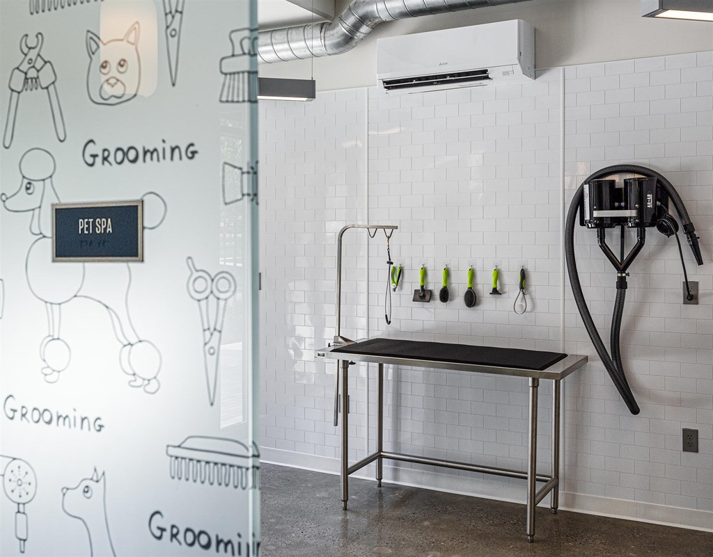 a white tiled kitchen with a sink and a shower with tools on the wall