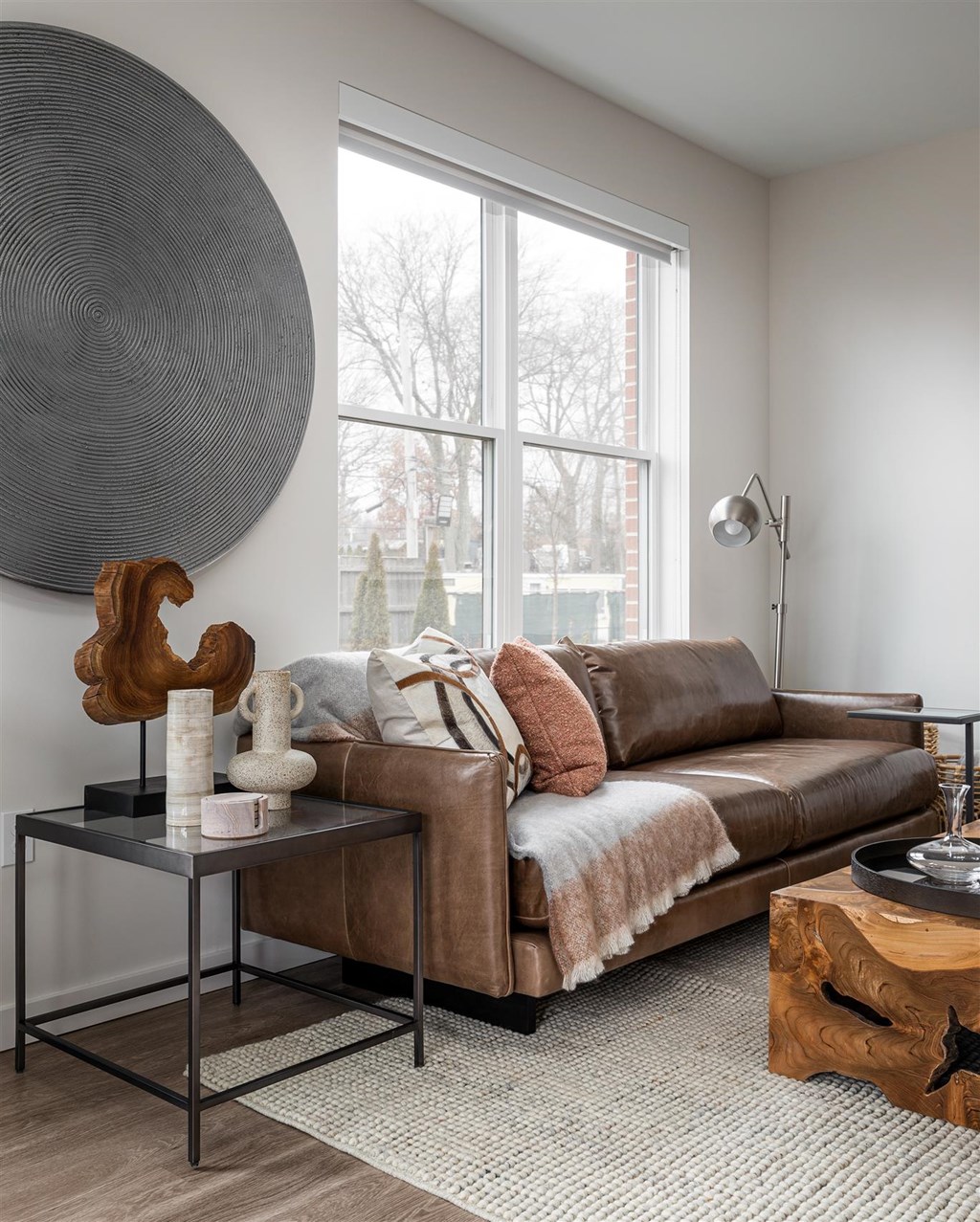 a living room with a brown couch and a large window