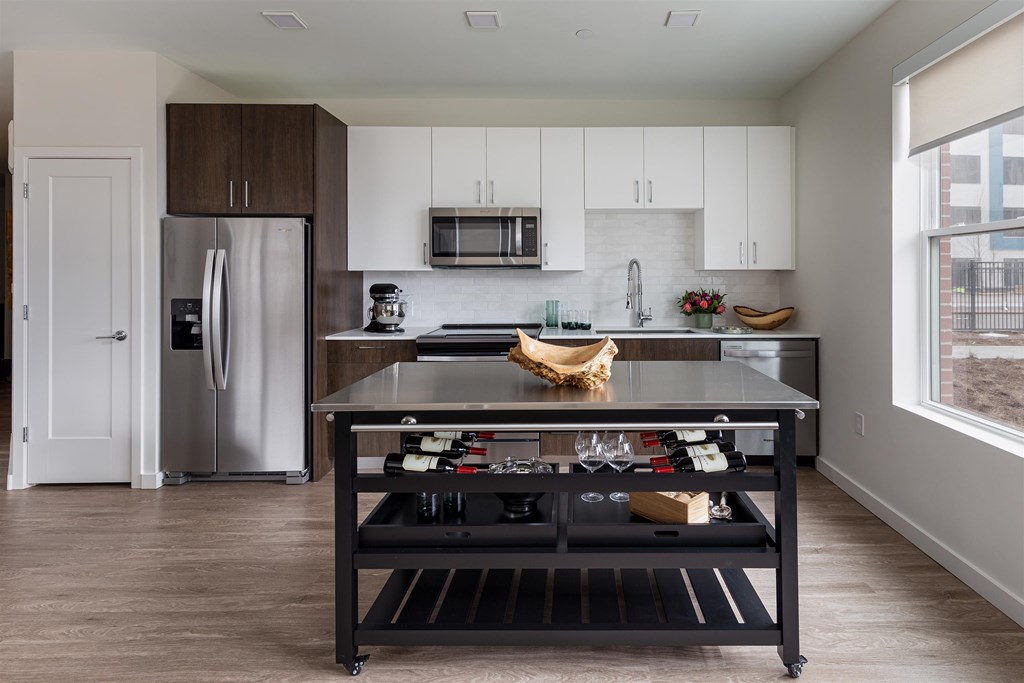 a kitchen with a black island and a stainless steel refrigerator