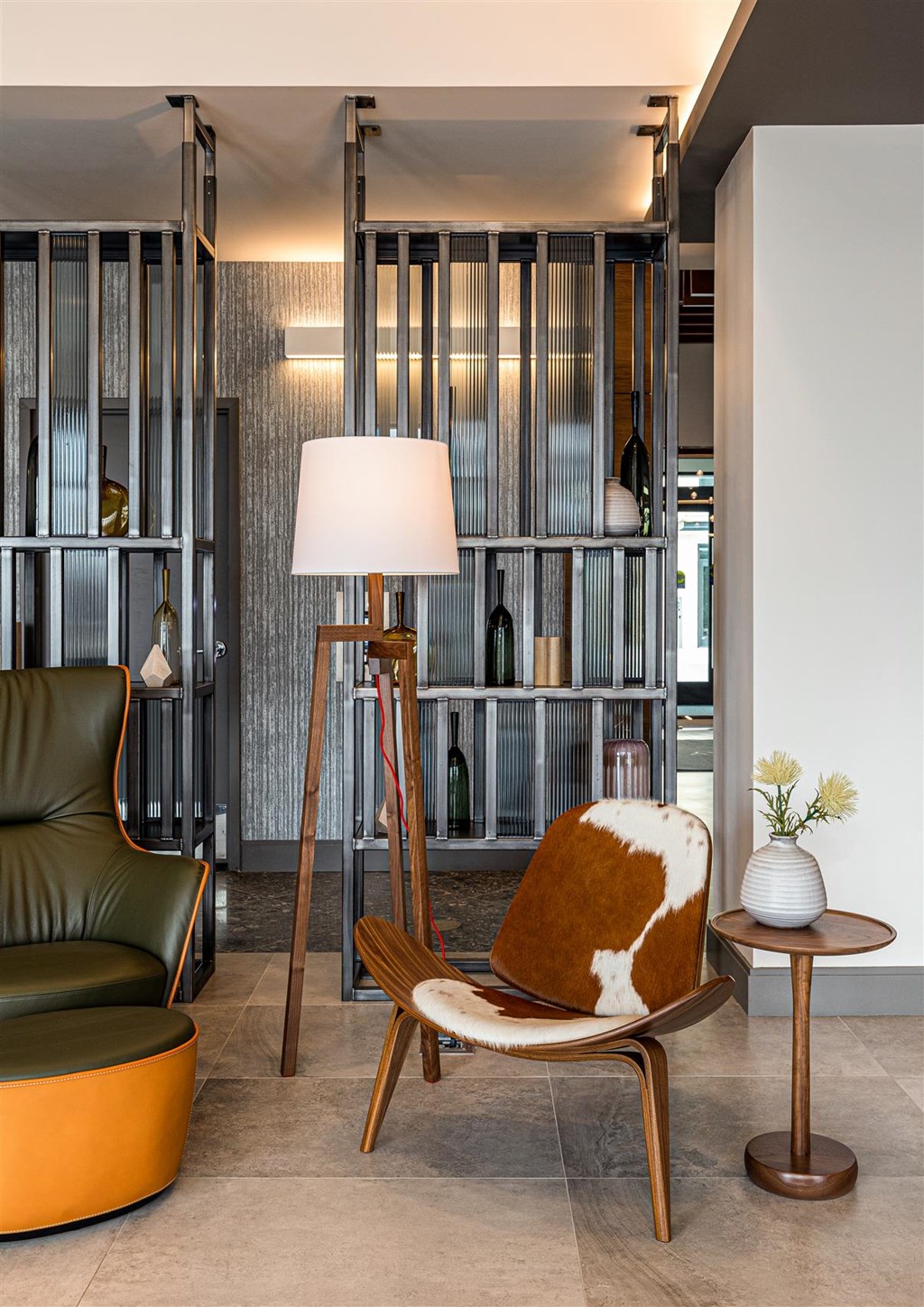 a living room with a chair and a floor lamp