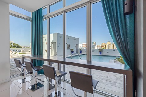 a dining room with a view of a pool and a table with chairs