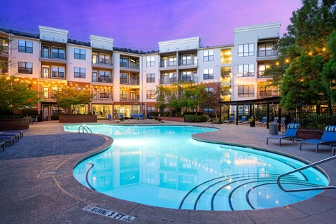A large swimming pool in front of apartment buildings.